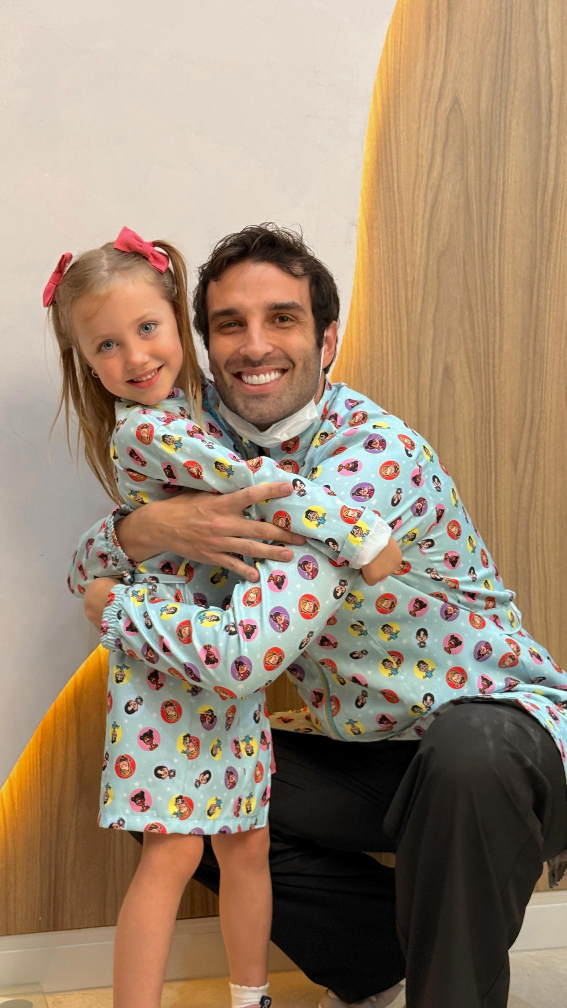 Criança abraçando o doutor com avental colorido